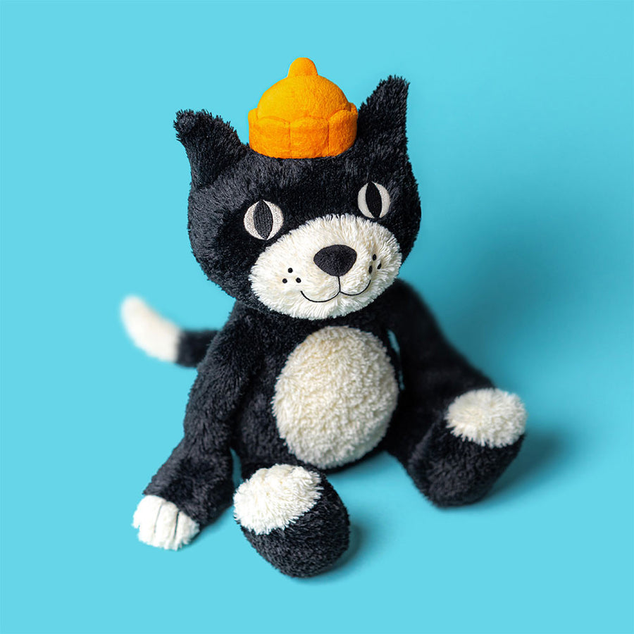Jellycat Jack kosekatt sett forfra – svart plysj med kremfarget snute og oransje lue