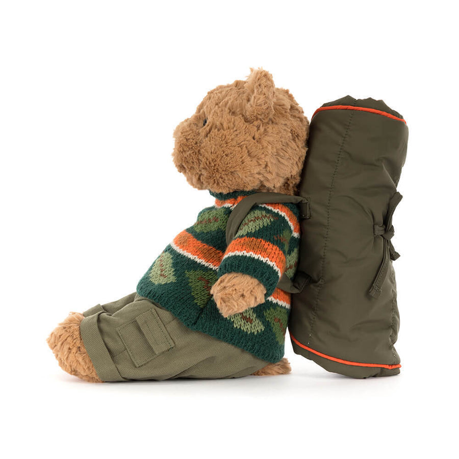 Nærbilde av Bartholomew Bear sitt turutstyr – stripet genser i beige og oransje